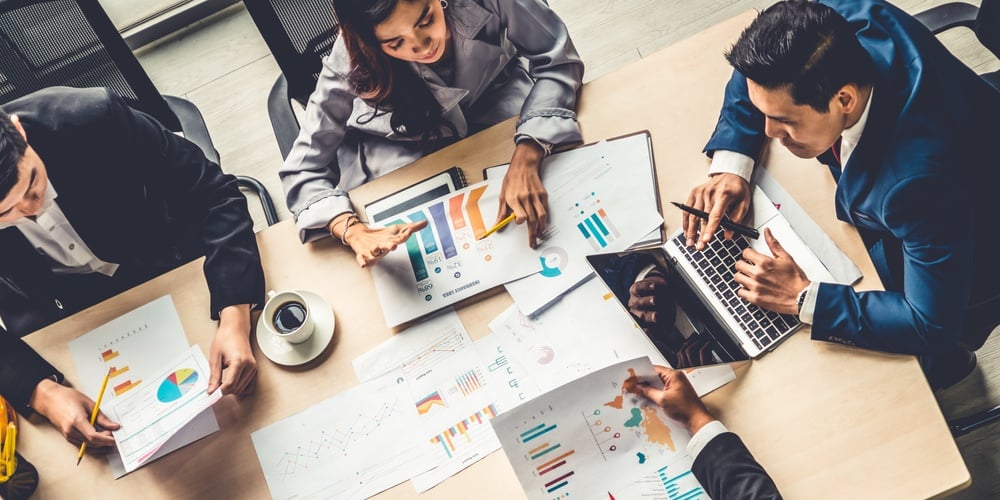 sales professionals sitting at a table looking at sales metrics